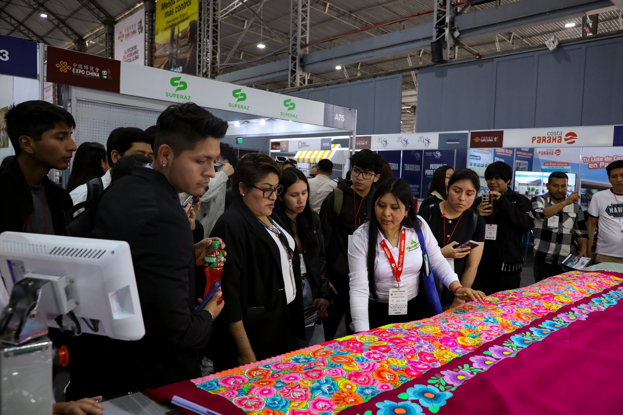 Clientes revisando bordados en la feria
